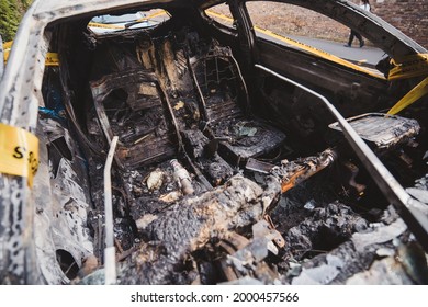 London | UK - 2021.06.12: Interior Of An Abandoned, Stolen Burnt Out Blue Car Parked On The Sideway Parking Spot б Tied With Yellow Do Not Cross Stripe