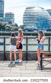 London, UK - 21 June, 2022: Family Enjoying The View On The Thames River Walk At Summer Sunny Day.  Street Photography