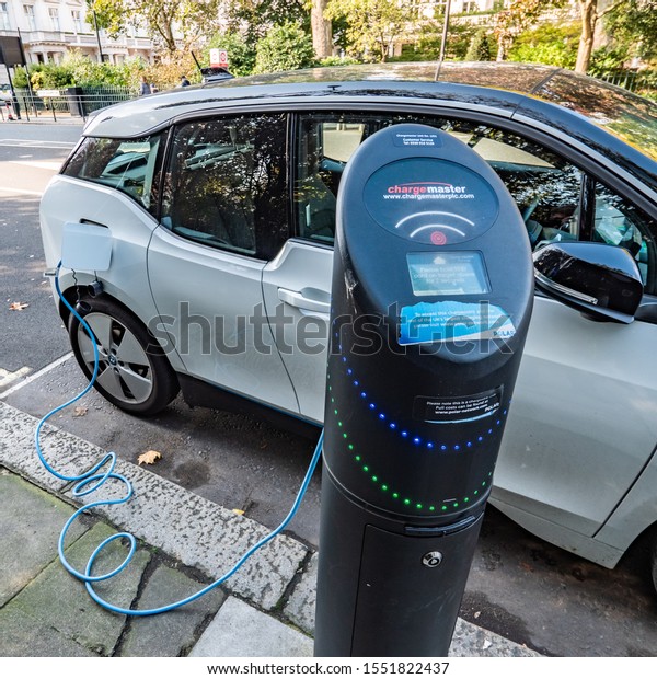 LONDON, UK - 22 OCTOBER 2019: An electric car\
plugged into a public charging point on the streets of Kensington,\
West London.