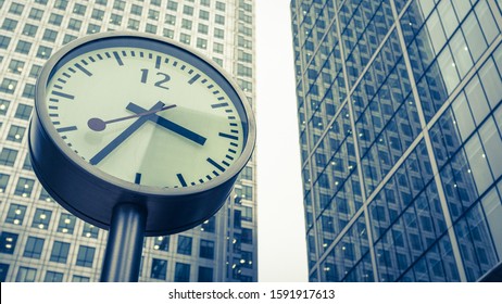 LONDON, UK - 23 OCTOBER 2012: Docklands Clocks. The Face To One Of The Six Public Clocks Found At The Foot Of Canary Wharf With The Tower Visible In The Background.