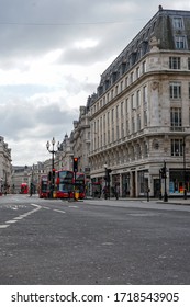 London, UK - 28 March 2020: Classic Red London Double Decker Buses Approaching Oxford Circus From Great Portland Street. Empty Streets. All Shops And Restaurants Closed Due To The Covid-19 Lockdown.