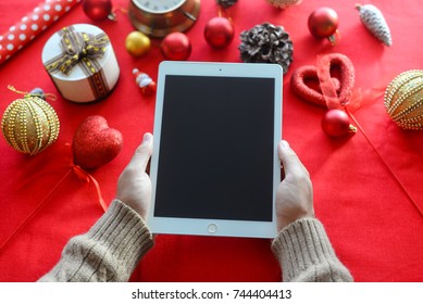 London, UK - 28 October 2017: Closeup On Person Hands Using Apple Ipad 2 Smart Tablet At Christmas Festive Table Background. Communication Technology Mockup Abstract Background. Joyful Happy Fun Time