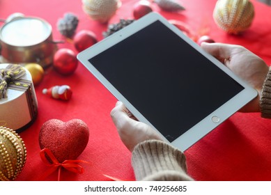 London, UK - 28 October 2017: Closeup On Person Hands Using Apple Ipad 2 Smart Tablet At Christmas Festive Table Background. Communication Technology Mockup Abstract Background. Joyful Happy Fun Time