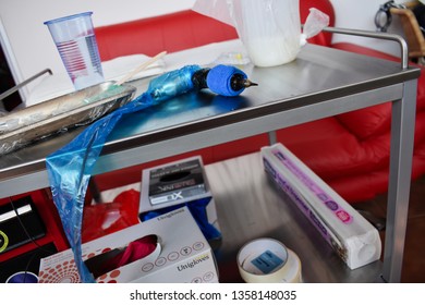 London, UK - 29 March 2019: Tattoo Equipment And Machine With Ink Bottles And Sterile Gel Products For Tattooing On A Table Work Bench Area In A Body Art Studio.