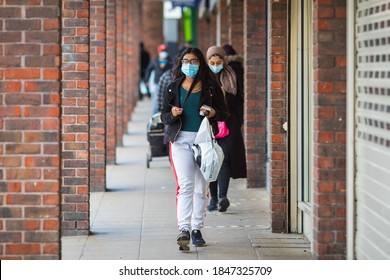 London, UK - 3 November, 2020 - A young woman wearing a face mask while shopping at Walthamstow market