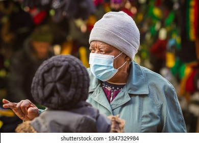 London, UK - 3 November, 2020 - A senior black woman wearing a face mask while talking to her friend at Walthamstow market