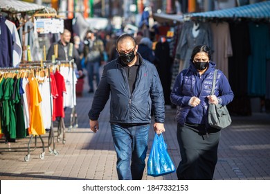 London, UK - 3 November, 2020 - An Asian couple wearing face masks while shopping at Walthamstow market