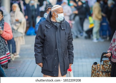 London, UK - 3 November, 2020 - An Asian Muslim man wearing a mask while shopping at Walthamstow market