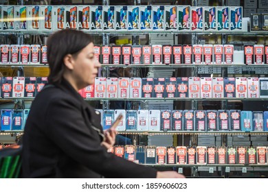 London, UK - 3 November, 2020 - A Display Window Of Second Hand Mobile Phone Shop In Walthamstow, With A Pedestrian Passing By