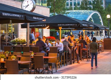 LONDON, UK - 7 SEPTEMBER, 2015: Canary Wharf Night Life. People Sitting In Local Restaurant After Long Hours Working Day