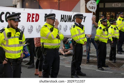 London UK - 8 23 2021: An Extinction Rebellion Climate Change Protestor And Police In London's Covent Garden (Long Acre).