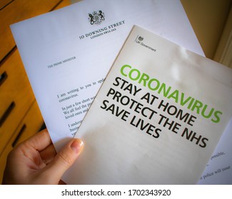 London, UK - April 10 2020: Person Holding Official UK Government Instructions To Stay At Home Due To Corona Virus Lockdown In Force