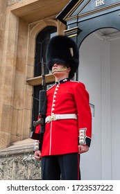 London, UK - April, 2019: English Guard Soldier. Solider Guard Of Buckingham Palace, London England. Royal Guard Of London At A Post In Buckingham Palace, Close-up Portrait, View From The Bottom.