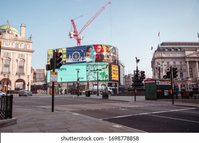 London, UK - April 2020: Piccadilly Circus During Coronavirus Lockdown. Stay Home Sign. NHS Support. Iconic London Landmark With Famous Billboard And Traditional London Bus.