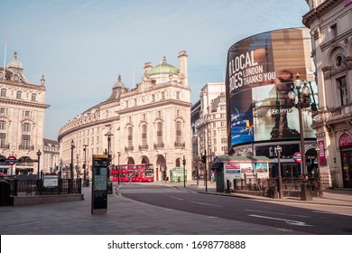 London, UK - April 2020: Piccadilly Circus During Coronavirus Lockdown. Stay Home Sign. NHS Support. Iconic London Landmark With Famous Billboard And Traditional London Bus.