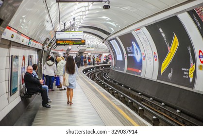 LONDON, UK - APRIL 22, 2015: People Waiting At Underground Tube Platform For Train Arrives