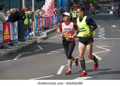 London, UK - April 23, 2017: London Marathon, Disabled Athlete Running Distance With Guide Runners In Canary Wharf