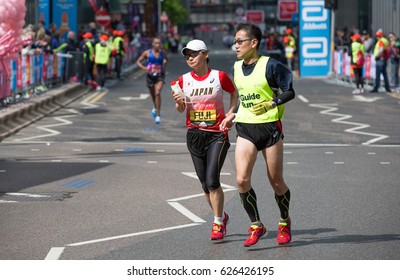 London, UK - April 23, 2017: London Marathon, Disabled Athlete Running Distance With Guide Runners In Canary Wharf