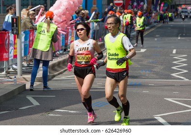 London, UK - April 23, 2017: London Marathon, Disabled Athlete Running Distance With Guide Runners In Canary Wharf