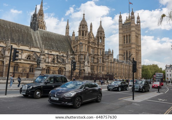 LONDON, UK - APRIL 25, 2017: Traffic on\
Abingdon St with House of Lords in the\
background.