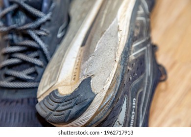 London, UK - April 27, 2021: Close up of a pair of black running shoes. Signs of wear and tear. Overpronation (supination) wear signs in the outside of the sole (heel). Asics gel cumulus 20