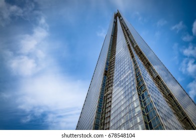 London, UK - April 28, 2016: Upward View With A Closeup N The Shard Surrounded By Clouds And The Blue Sky. The Shard Is Currently The Tallest Building In The European Union And A London Landmark.