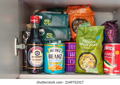 London, UK: April 8, 2022: Cupboard Shelves Full Of Food Provision, Such As Pasta, Rice, Porridge, Canned Tuna, Beans And More. Panic Buying To Survive Pandemic Or Food Crisis