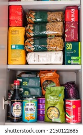 London, UK: April 8, 2022: Cupboard Shelves Full Of Food Provision, Such As Pasta, Rice, Porridge, Canned Tuna, Beans And More. Panic Buying To Survive Pandemic Or Food Crisis