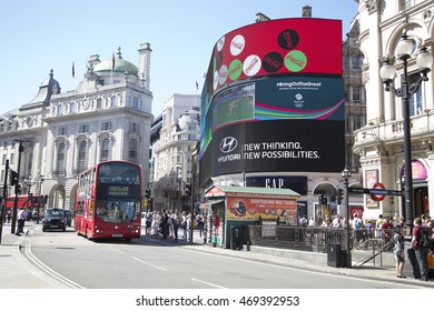 LONDON, UK - AUG 12, 2016. Red Bus Passing Busy Street And Large Screen In Piccadilly Circus