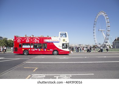 LONDON, UK - AUG 12, 2016. Site seeing bus drives over westminster bridge with london eye in background