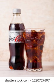 LONDON, UK - AUGUST 03, 2018: Plastic bottle and original glass of Diet Coke Coca Cola soft drink on wood. Most popular drink in the world.