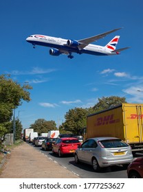 London, UK, August, 2019: A British Airways Boeing 787 Dreamliner Flying Into Heathrow Over Congested Road With Cars And Trucks In Traffic Causing Serious Environmental Pollution. Image Abdul Quraishi