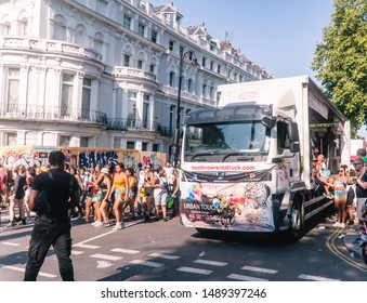 London, UK - August 2019: Notting Hill Carnival Celebrations And Parade. Truck Float Cart Heathrow. Crowds Of People On Procession Route. Ladbroke Grove. Partygoers Having Fun.