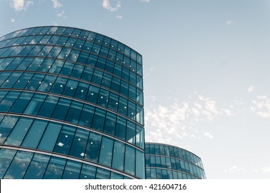 LONDON, UK - AUGUST 21, 2015: Modern office building. Clouds reflections on the glass and detail of a curtain wall. Designed by Norman Foster