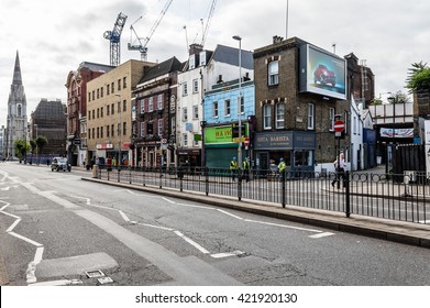 LONDON, UK - AUGUST 25, 2015: London street scene. Westminster Bridge Roadwith construction cranes ans retail stores on a overcast day