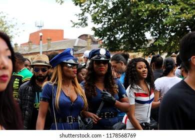London, UK - August 27, 2018:  Attractive young women alluring in a costume of police officer