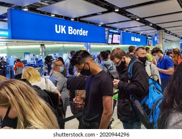 London, UK- August 6, 2021: Air Travelers With Face Mask Queuing At UK Border Control In Heathrow Airport, London. 