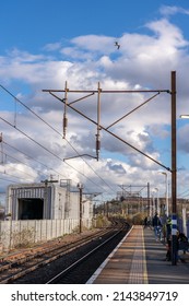 LONDON, UK - CIRCA 2022 APRIL: OVerhead Electrification System Above Railway Tracks, Against A Blue Sky With A Few Clouds. Electrified Train Track.