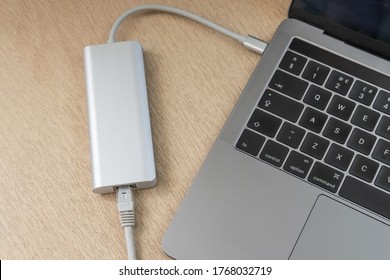 London, UK - Circa July 2020: Top Down View Of A Modern, Luxury Laptop Computer Seen Connected To A USB-C Ethernet Multifunction Docking Station. Seen On An Office Desk.