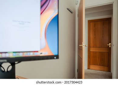 London, UK - Circa July 2021: Shallow Focus Of Distant Doors Seen In A Large House Setting. A Nearby Computer Screen Is Located In A Home Office Environment.