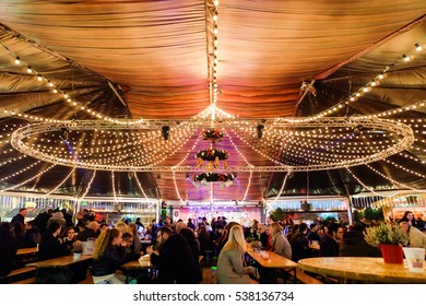 LONDON, UK - DECEMBER 14, 2016: People at Winter Wonderland in Hyde park enjoy food and drink at night during Christmas and New years celebrations in London, United Kingdom.