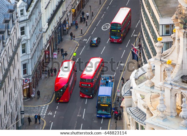 London, UK -\
December 19, 2016: London red busses at the City of London road.\
View down from the office block\
