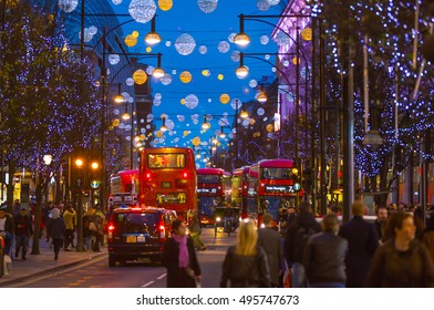 LONDON, UK - DECEMBER 30, 2015: Christmas lights decoration at Oxford street and lots of people walking during the Christmas sale, public transport, buses and taxi