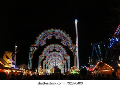 LONDON, UK - DECEMBER 5, 2015: Winter Wonderland Christmas market in Hyde Park, London, England. Colorful, illuminated arches light the entrance on a dark winter night.
