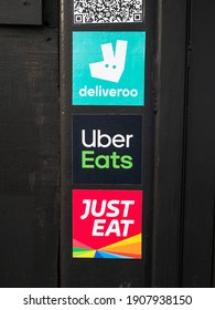 London UK, February 2021: Fast Food Delivery Stickers On A Street Wall, Advertising For Deliveroo, Uber Eats And Just Eat. Home Delivery Service, During Covid-19, Coronavirus Pandemic. London Lockdown