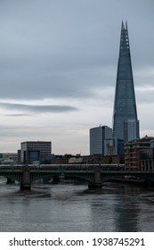London UK February 2021 View of the river Thames on a cold bland winter day, The Shard skyscraper rising above the buildings. White train crossing the river over a bridge