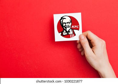 LONDON, UK - February 21st 2018: Hand holidng aKFC fast food sign. KFC is an american fast food company that specializes in chicken