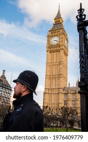 London, UK - February 4, 2017: Juxtaposition with closeup of a guard and the Big Ben Clock tower in the background.