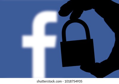 LONDON, UK - FEBRUARY 5th 2018: Facebook Security Issues. Silhouette Of A Hand Holding A Padlock Infront Of The Facebook Logo