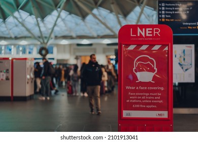 London, UK - January 01, 2022: Wear A Face Mask Sign On A LNER Board Inside The Hall Of Kings Cross Train Station. The Requirements Were Introduced Due To Coronavirus Pandemic. 